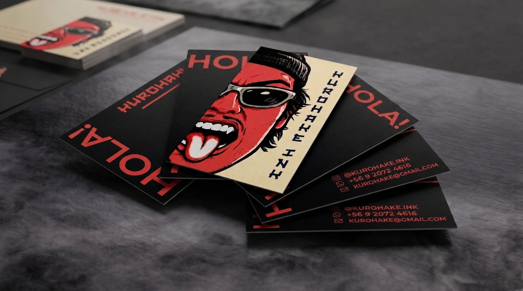 Tarjetas de Hurohake Ink Tattoo con ilustración roja, negra y marfil sobre una superficie gris